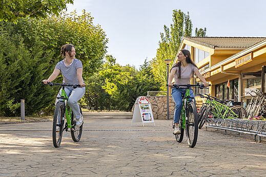 Zwei Frauen radeln, Fahrradverleih auf CAPFUN El Escorial Camping, Madrid.
