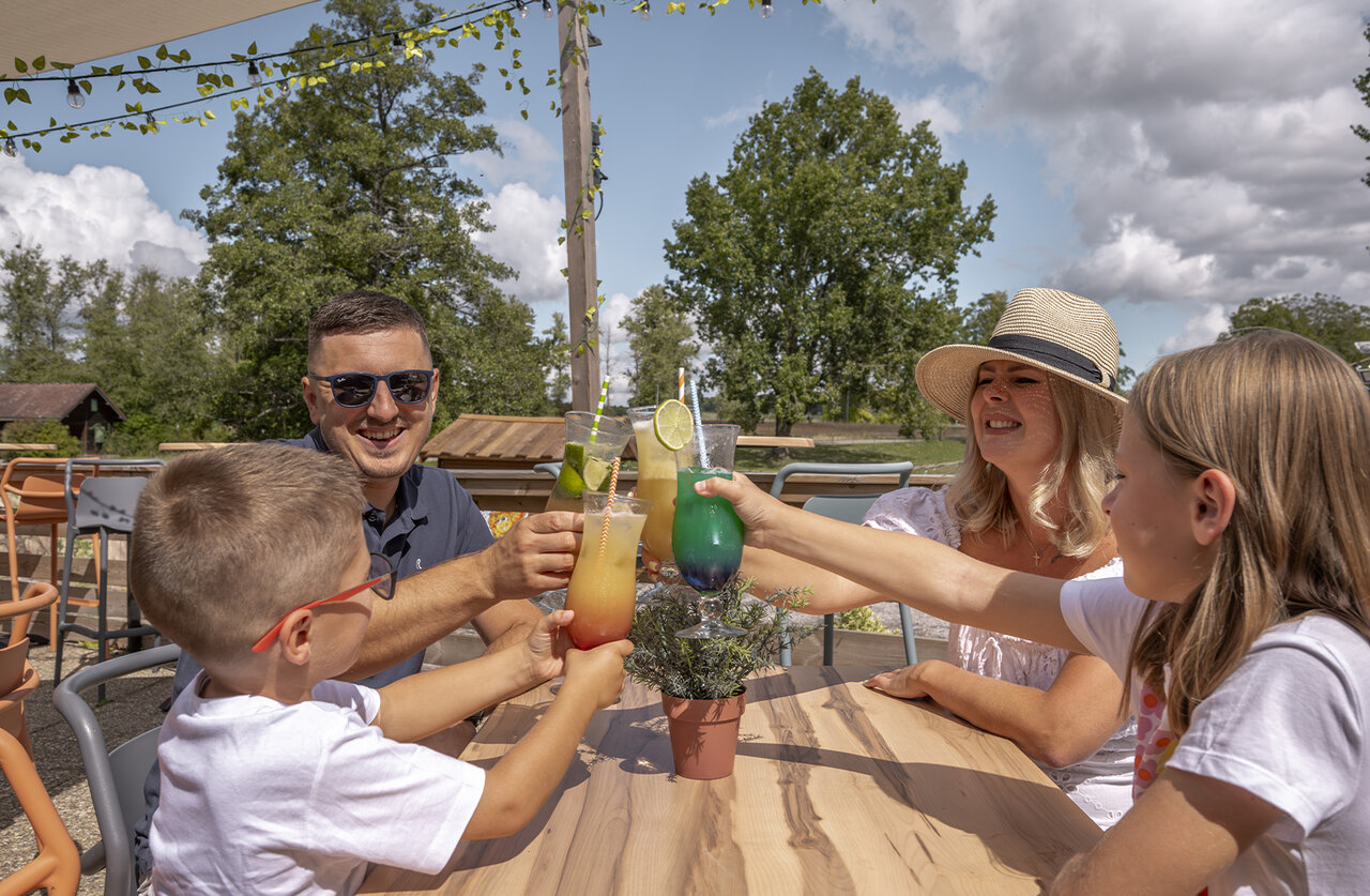 Famille trinquant cocktails sur terrasse bar au camping CLICOCHIC � HARPRICH.