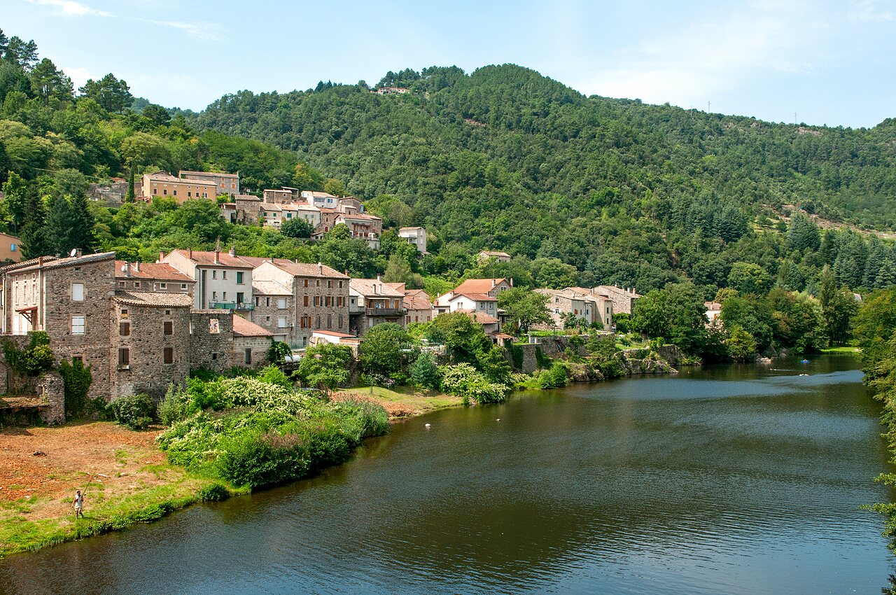 Picturesque village by a river, surrounded by green mountains in Ard�che.