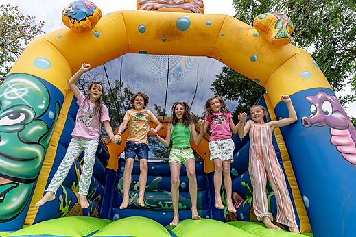 Hüpfburg und fröhliche Kinder auf dem Campingplatz CLICOCHIC Eyrieux in Les OLLIERES-SUR-EYRIEUX.