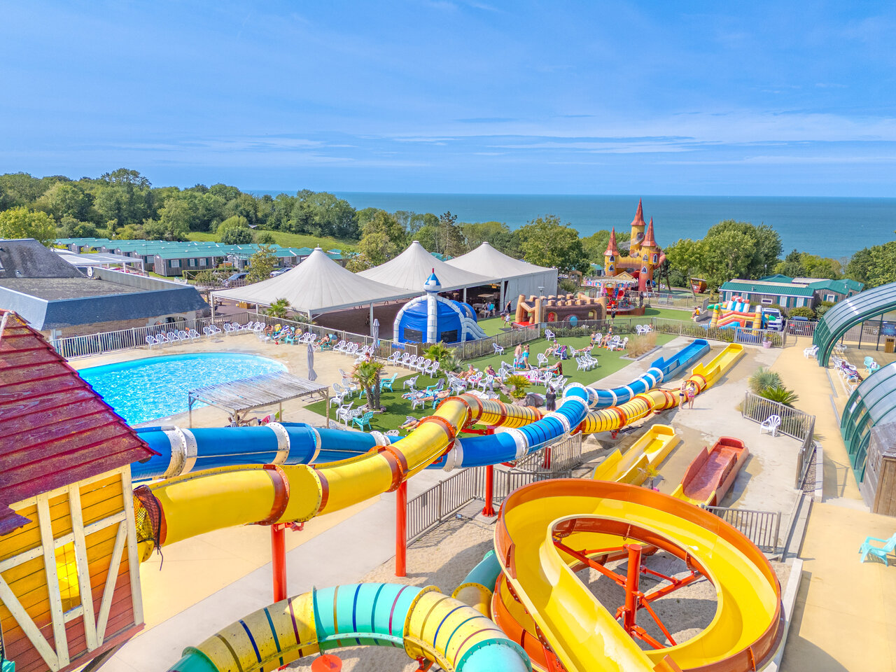 Bunte Wasserrutschen, Schwimmbad und Spielbereiche auf Campingplatz CAPFUN Falaises in Gonneville sur Mer.