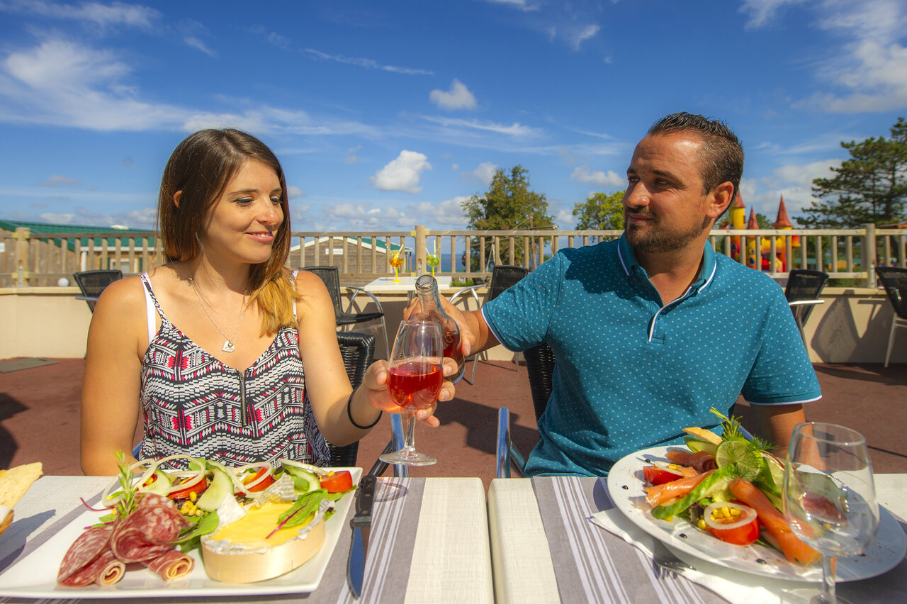 Paar beim Mittagessen auf der Terrasse des Restaurants auf dem Campingplatz CAPFUN Falaises in Gonneville sur Mer (14).