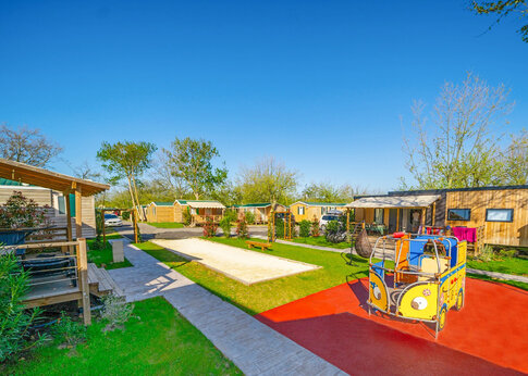 Bunter Spielplatz, Bouleplatz und Mobilheime auf dem Campingplatz CAPFUN F�erix in MARSEILLAN PLAGE (34).