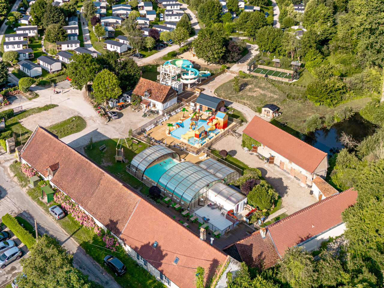 Water park, covered pool and accommodations at CLICOCHIC Ferme des Aulnes campsite in NAMPONT SAINT MARTIN.
