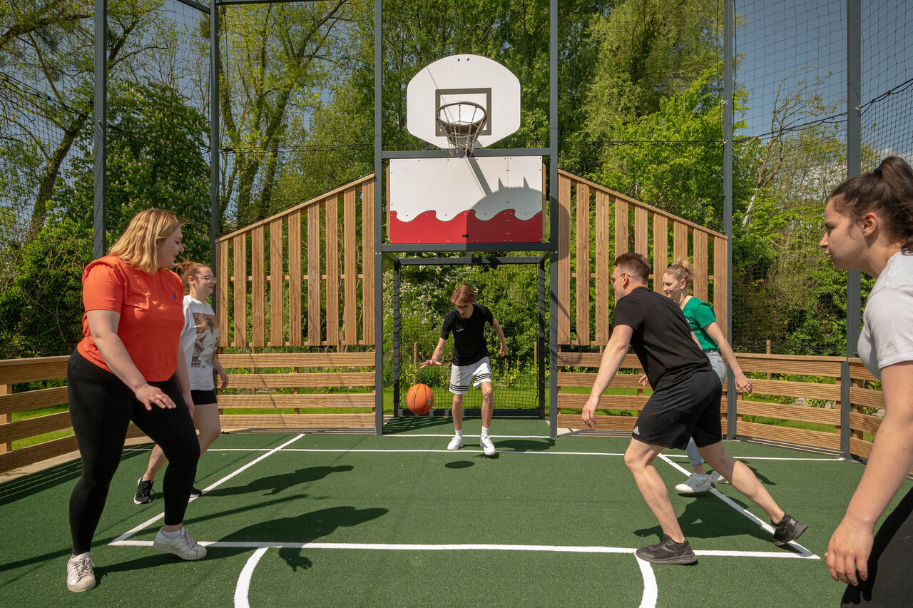 Multisport court, young people playing basketball, CLICOCHIC Ferme des Aulnes campsite (80).