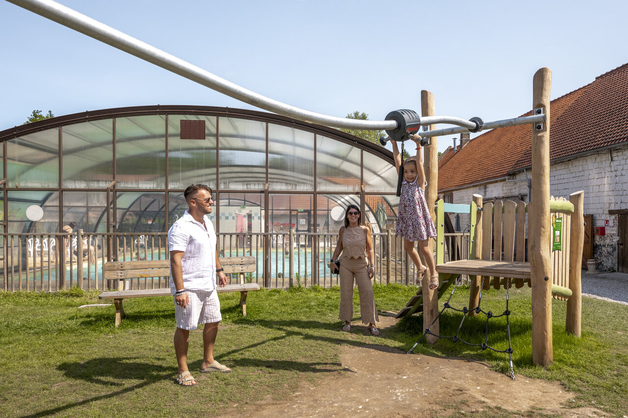 Playground and indoor swimming pool at CLICOCHIC Ferme des Aulnes campsite.