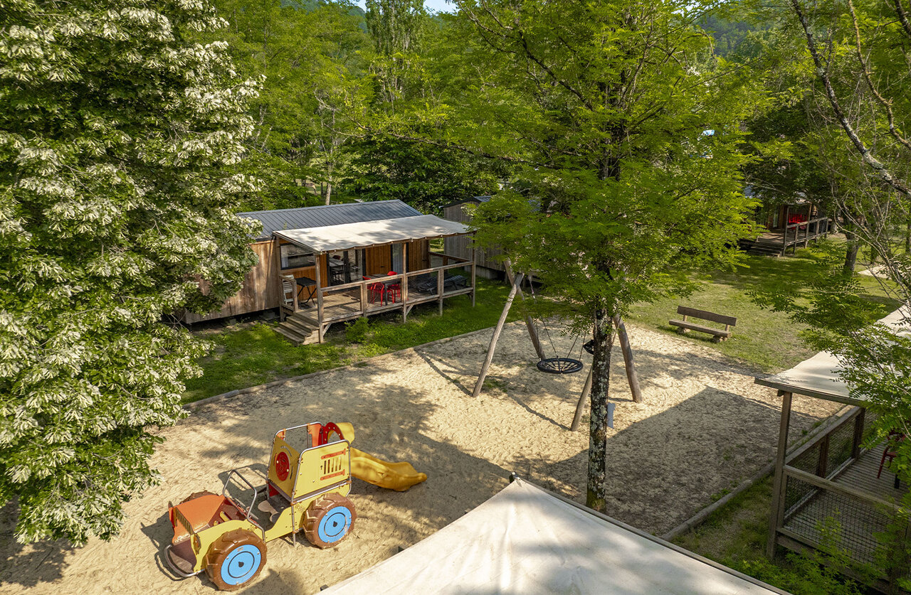 Aire de jeux sable, balan�oire, tracteur, mobile homes au camping CLICOCHIC Filament � Thoiras.