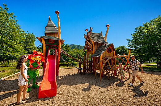 Holzspielplatz mit Rutsche und Maskottchen auf dem Campingplatz CLICOCHIC Filament in Thoiras (30).