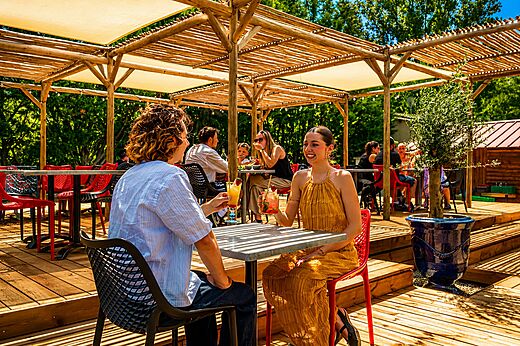 L�chelndes Paar genie�t Cocktails auf der Barterrasse auf dem Campingplatz CLICOCHIC Filament in Thoiras (30).