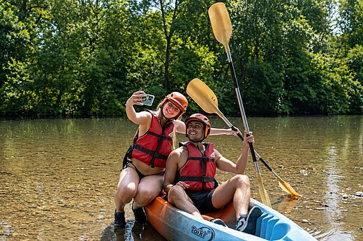 Twee lachende personen in kajak op rivier, selfie makend op camping CLICOCHIC Filament in Thoiras (30).