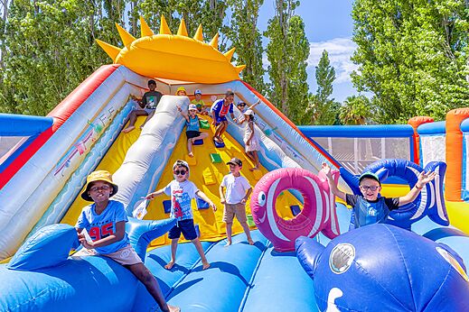 Kinder spielen auf einer gro�en H�pfburg mit Rutsche auf dem Campingplatz VAGUES OCEANES Au Flamenco in Argel�s-sur-Mer (66).