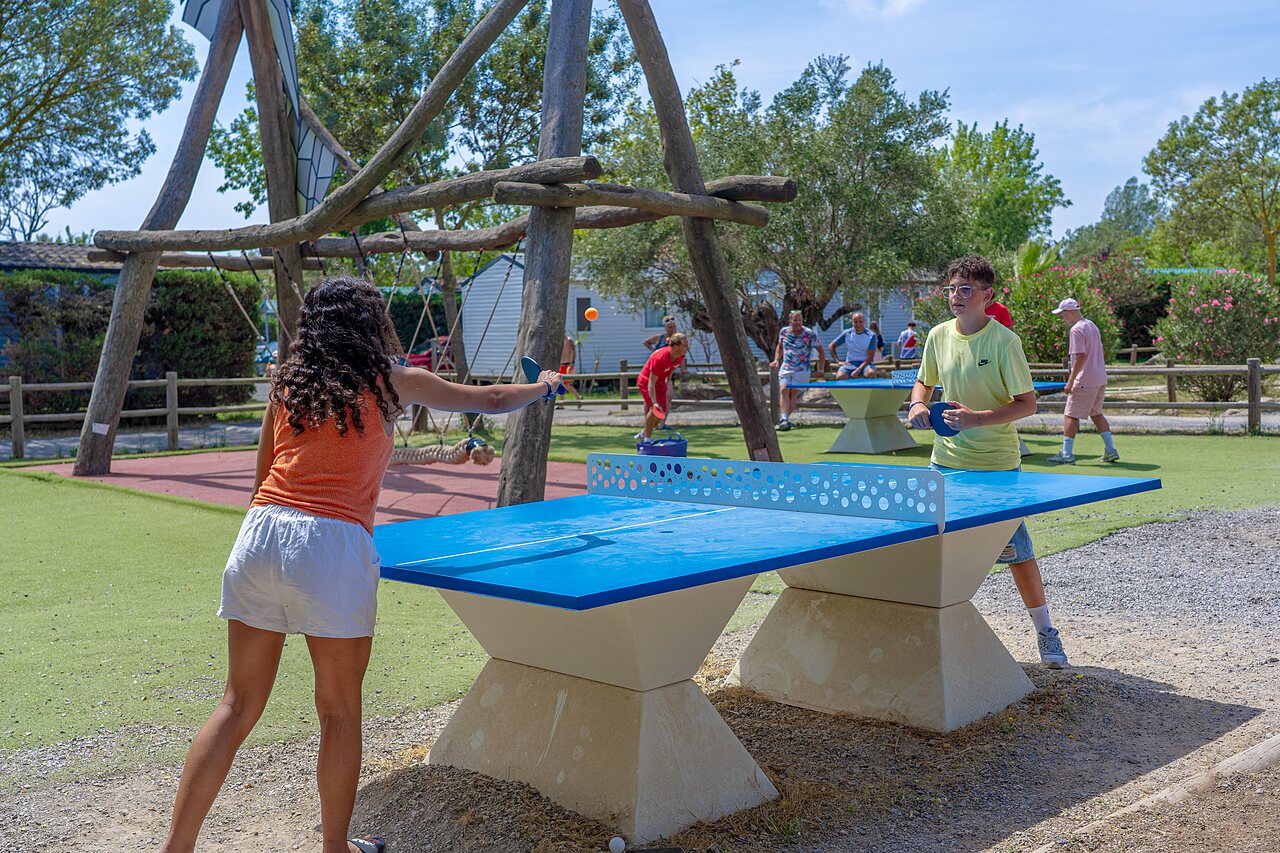 Jugendliche spielen Tischtennis drau�en auf Camping CAPFUN Fleurs d'Agde in AGDE.