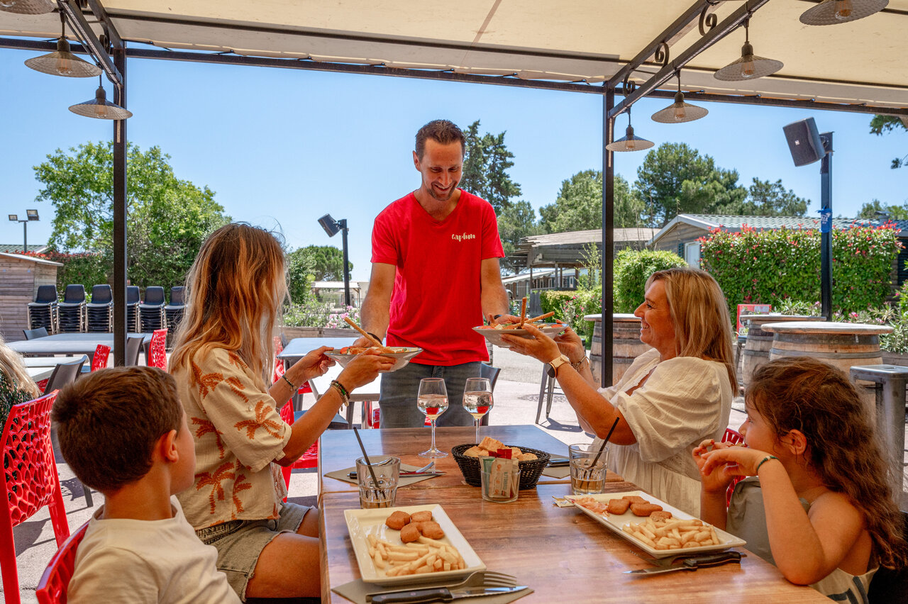 Familie isst auf dem Campingplatz CAPFUN Fleur de Camargue in Saint-Laurent-d Aigouze.