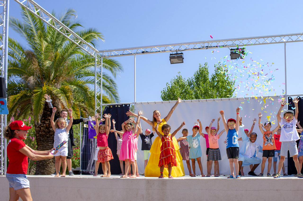 Fr�hliche Kinder und Animateure auf der B�hne mit Konfetti auf dem Campingplatz CAPFUN Fleur de Camargue in Saint-Laurent-d Aigouze (30).