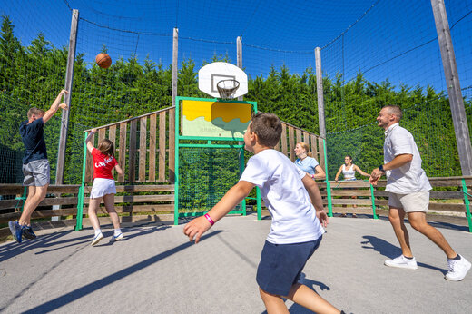 Multisportterrein met vakantiegangers die basketballen op camping CAPFUN Fleur de Camargue.