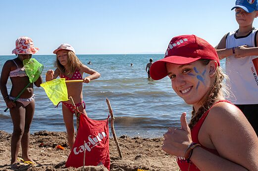 Kinderen spelen met netjes op het strand, lachende animator op camping CAPFUN Flots Bleus in VIAS PLAGE (34).