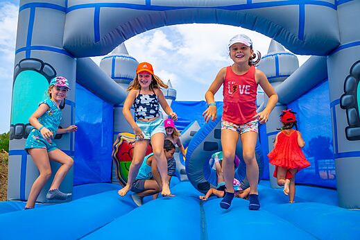 Opblaasbaar kasteel en springende kinderen op camping CAPFUN Flots Bleus in VIAS PLAGE (34).