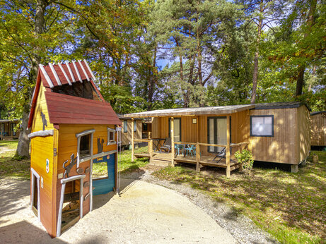 Kinderspielplatz und Holz-Mobilheime auf dem Campingplatz CLICOCHIC La Forêt d'Azalée (91).