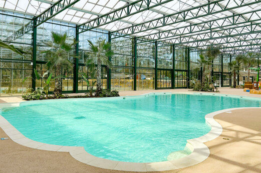 Beheiztes Hallenbad mit Palmen auf dem Campingplatz CLICOCHIC La For�t d'Azal�e.