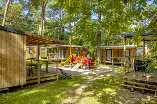 Holz-Mobilheime und Spielplatz auf dem Campingplatz CLICOCHIC La For�t d'Azal�e.