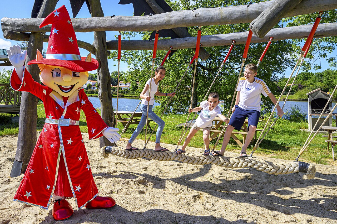 Maskottchen und Kinder spielen auf Seilbr�cke auf Camping CAPFUN Forges in Avrille (85).