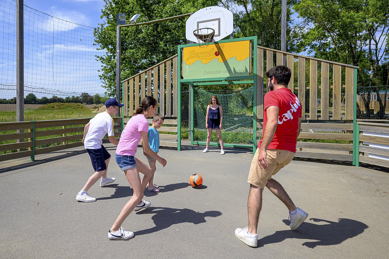 Familie spielt Fu�ball auf Multisportplatz CAPFUN Forges in Avrille (85).