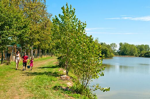 Familie angelt am Ufer des Natursees auf dem Campingplatz CAPFUN Forges in Avrille (85).