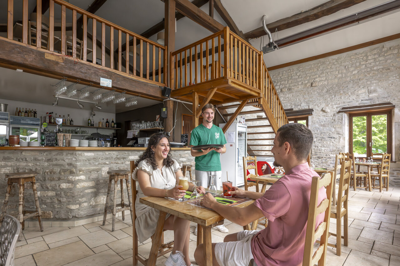 Restaurant-Bar-Innenbereich, Paar und Kellner auf Campingplatz CLICOCHIC Forge Sainte Marie Thonnance-les-Moulins.