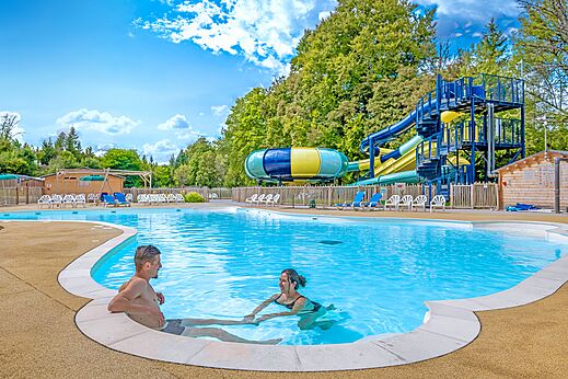 Swimming pool, slides and couple at CLICOCHIC Forge Sainte Marie campsite in Thonnance-les-Moulins (52).