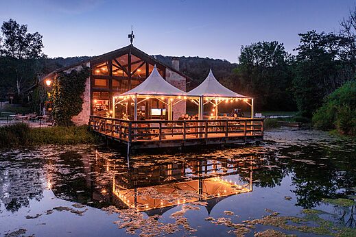 Restaurant-bar with illuminated terrace over water at CLICOCHIC Forge Sainte Marie campsite.