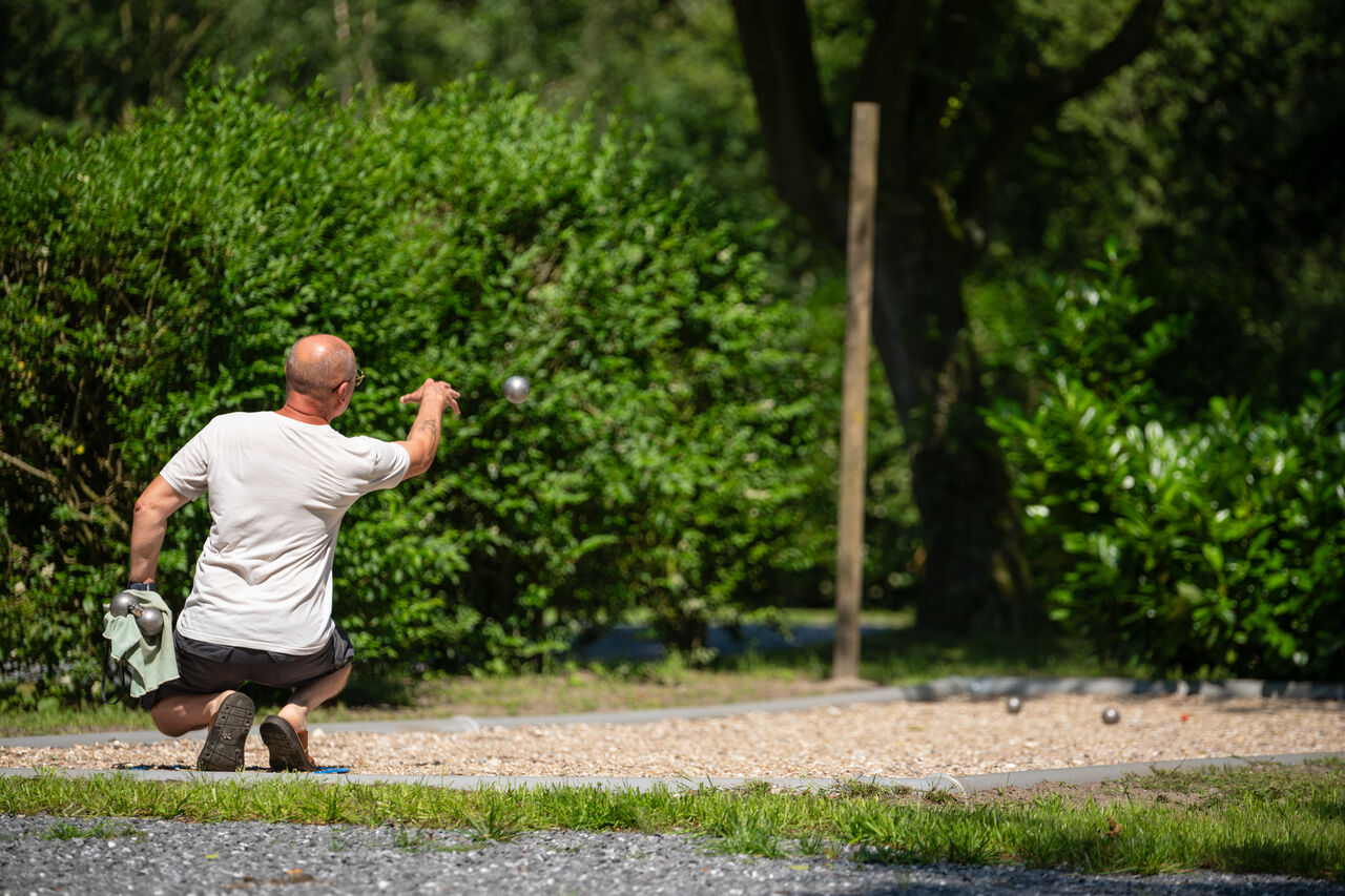 Mann spielt Boule auf einem Bouleplatz auf dem Campingplatz CAPFUN Fort Bedmar in Sint-Gillis-Waas.