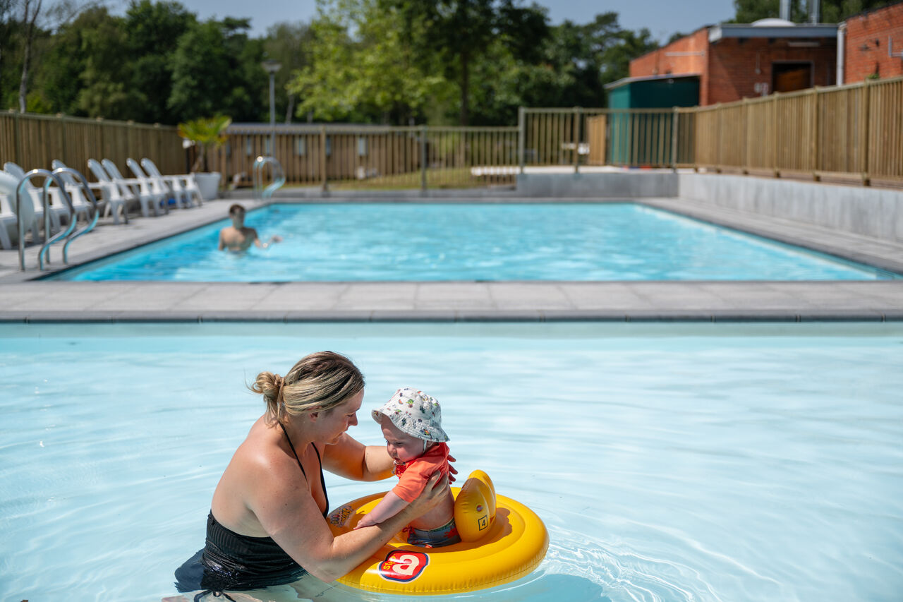 Mutter und Baby im Planschbecken auf dem Campingplatz CAPFUN Fort Bedmar in Sint-Gillis-Waas.