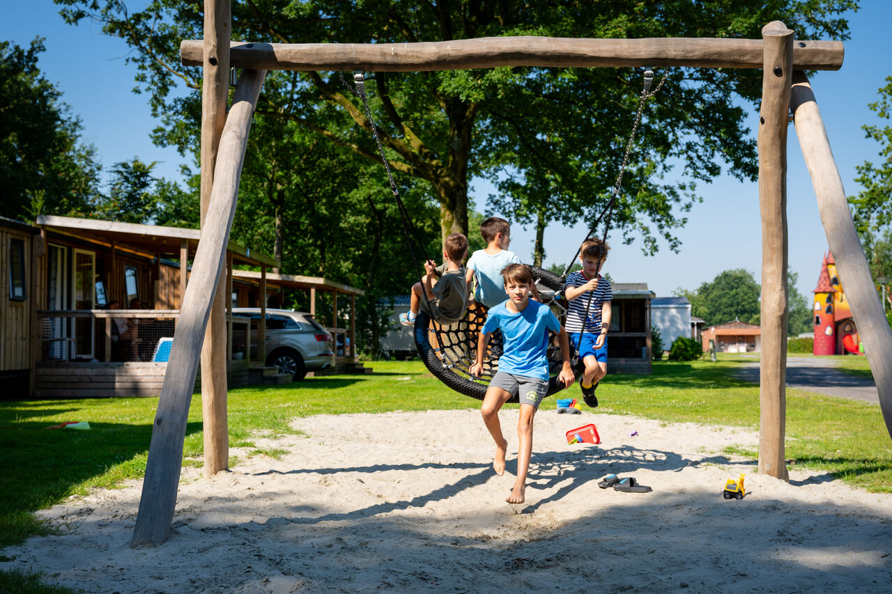 Kinder spielen auf Nestschaukel, Spielplatz auf dem Campingplatz CAPFUN Fort Bedmar.