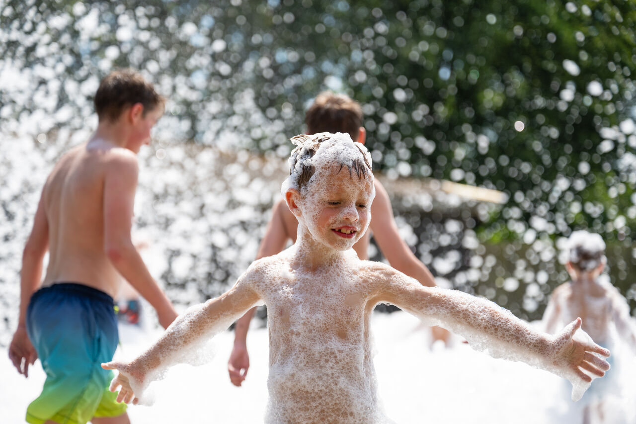 Fr�hliche Kinder spielen auf einer Schaumparty auf dem Campingplatz CAPFUN Fort Bedmar in Sint-Gillis-Waas.