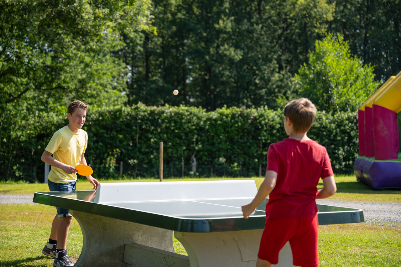 Zwei Jungen spielen Tischtennis im Freien auf dem Campingplatz CAPFUN Fort Bedmar in Sint-Gillis-Waas.