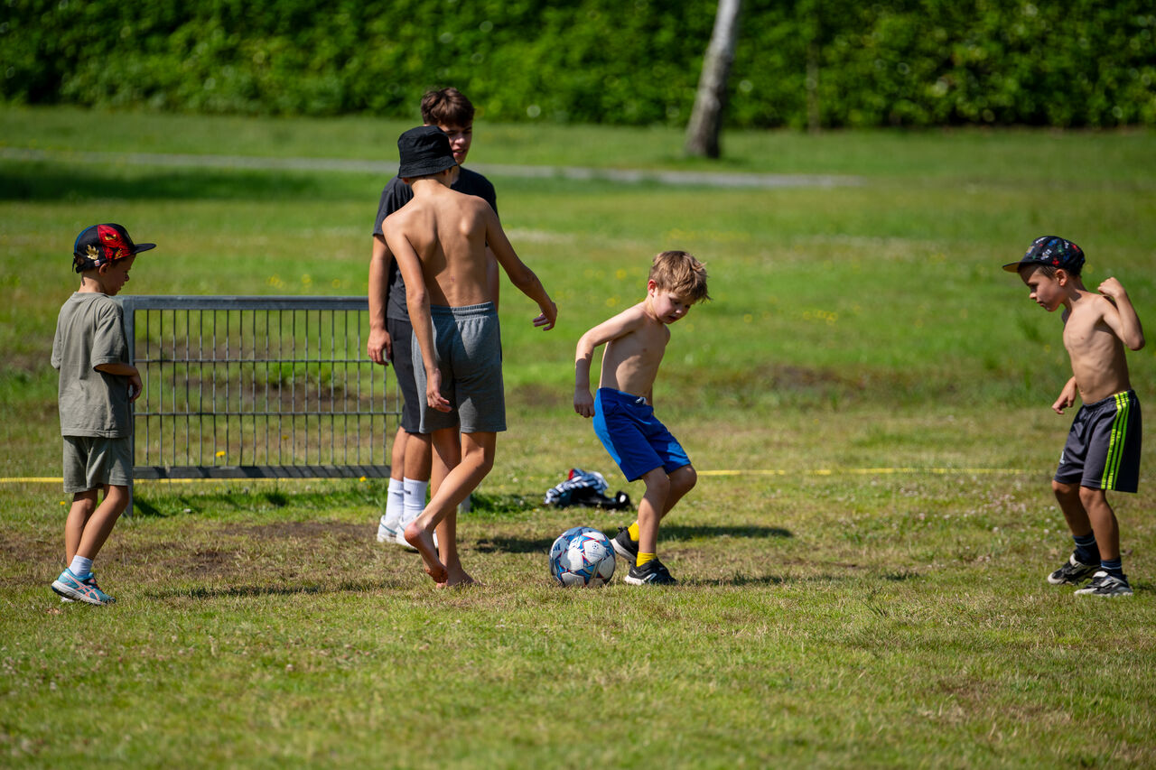 Kinder spielen Fu�ball auf einem Sportplatz auf dem Campingplatz CAPFUN Fort Bedmar in Sint-Gillis-Waas.