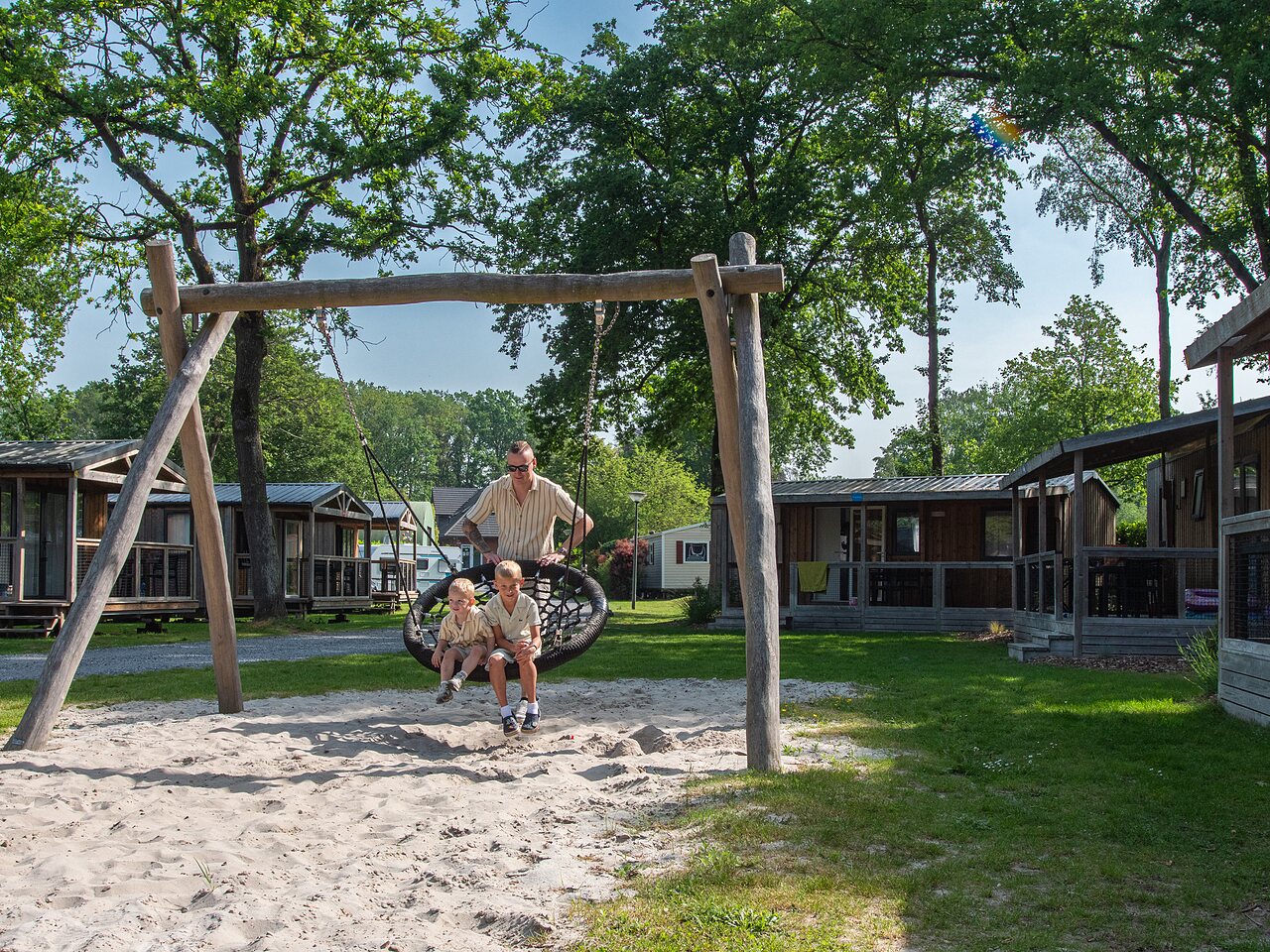 Kinder spielen auf Vogelnestschaukel am Campingplatz CAPFUN Fort Bedmar.