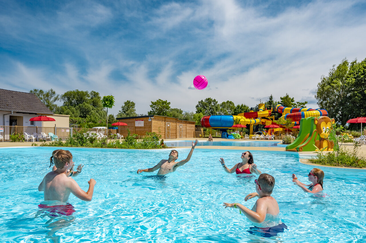 Familie spielt Ball im Pool mit Rutschen auf Camping CAPFUN Fort Falabraque in Seltz (67).