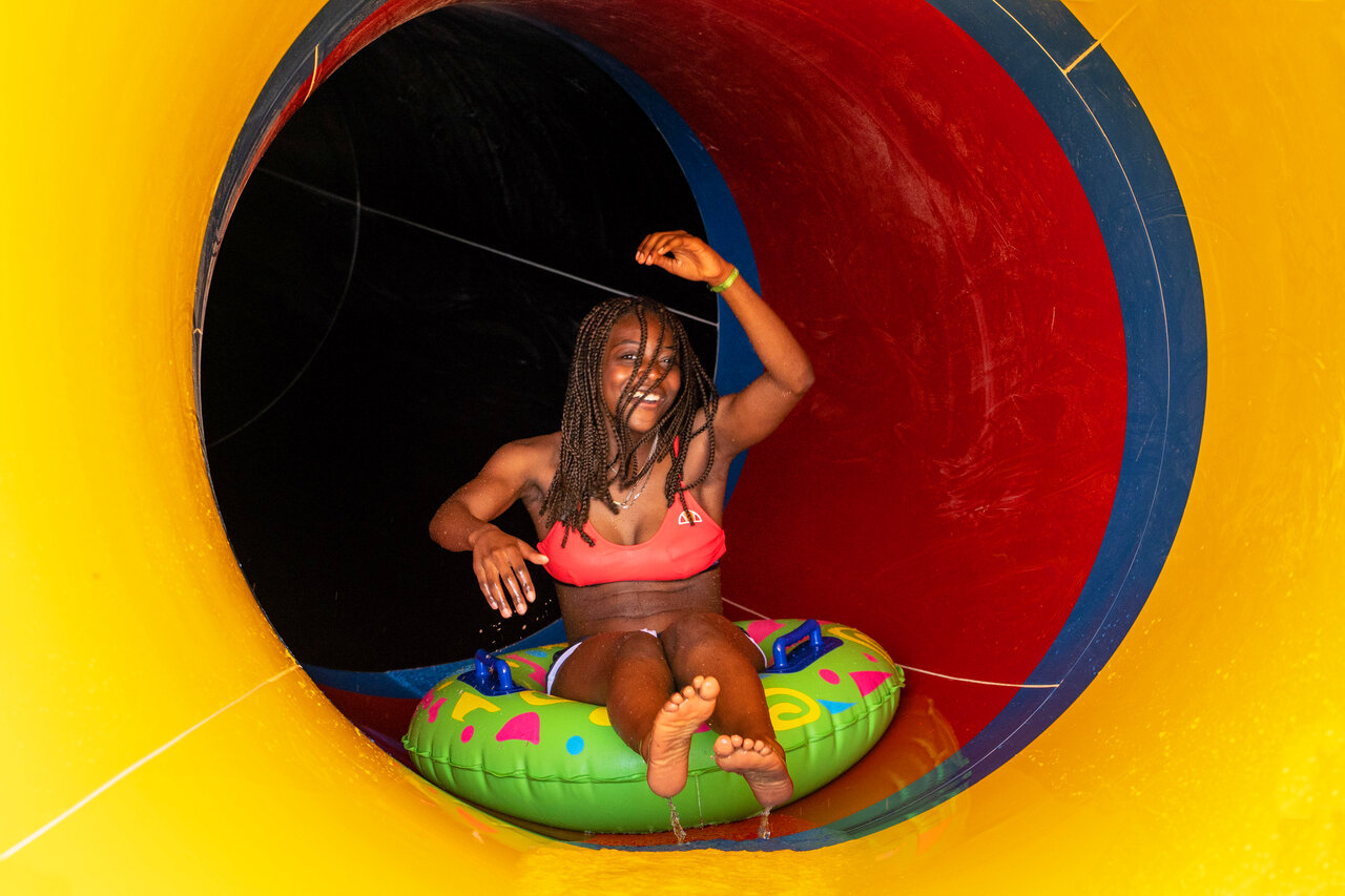 Junge Frau auf Reifen in Wasserrutsche, CAPFUN Fort Falabraque in Seltz.