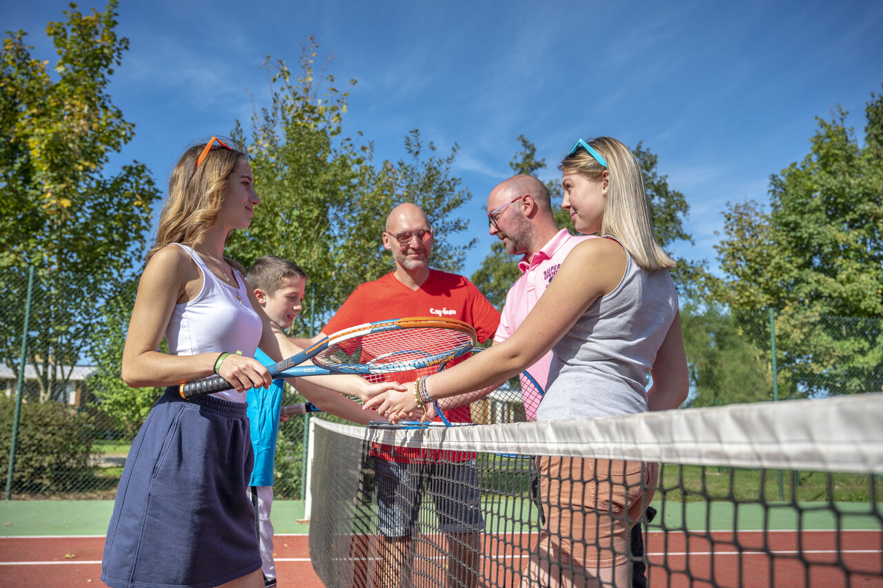 Familie und Animateure spielen Tennis auf dem Campingplatz CAPFUN Fort Falabraque in Seltz.