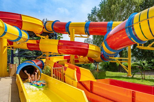 Kleurrijke waterglijbanen met vakantiegangers op camping CAPFUN Fort Falabraque in Seltz (67).