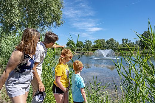 Teich mit Springbrunnen, Familie auf dem Campingplatz CAPFUN Fort Falabraque in Seltz (67).