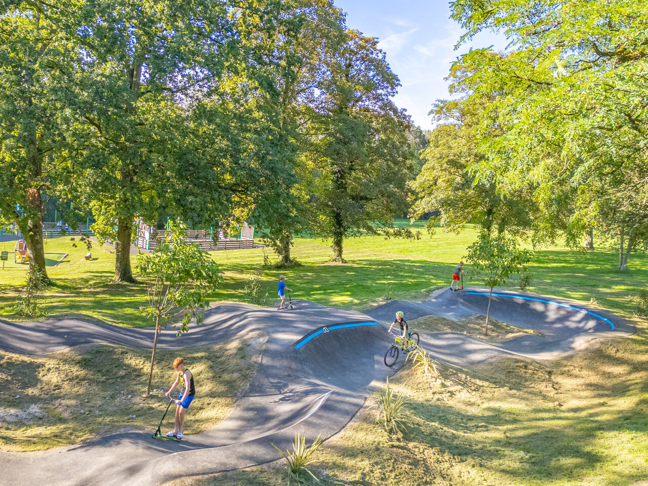 Moderner Pumptrack mit Kindern auf Roller und Fahrrad auf dem Campingplatz CAPFUN Fredland in Tournan en Brie (77).