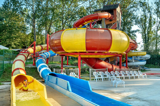 Bunte Wasserrutschen, Kind hat Spaß auf dem Campingplatz CAPFUN Fredland in Tournan en Brie.