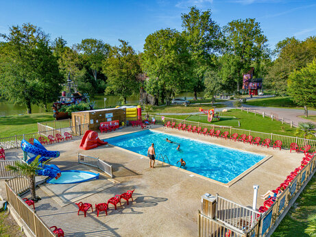 Piscine ext�rieure avec toboggans et chaises rouges au camping CAPFUN Fredland � Tournan en Brie (77).