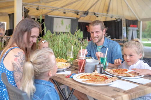 Famille souriante mangeant des pizzas au restaurant du camping CAPFUN Fredland � Tournan en Brie (77).