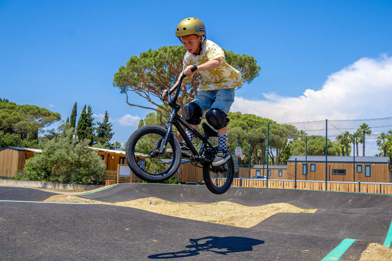 Kind auf BMX springt auf dem Pumptrack im Camping CAPFUN Le Fr�jus.
