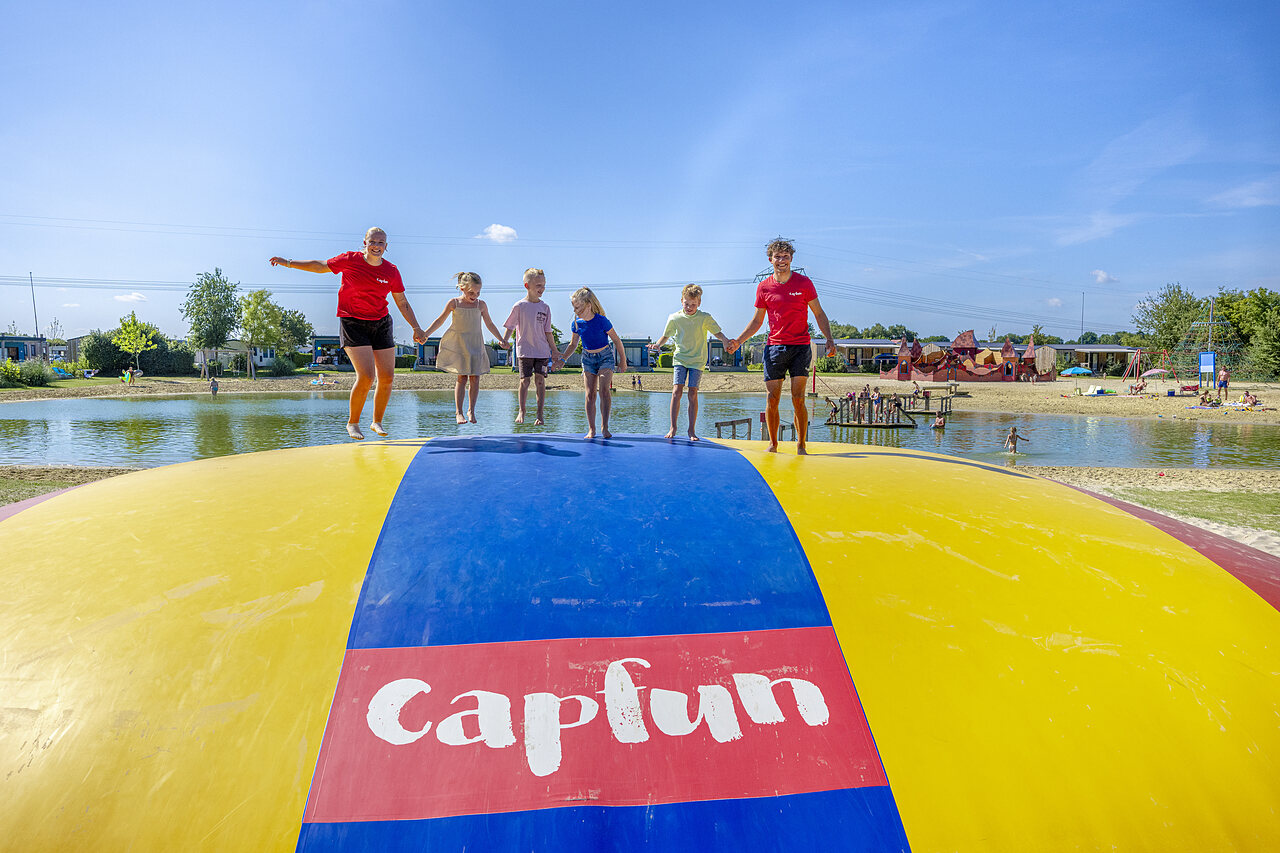Kinder und Animateure springen auf riesigem H�pfkissen bei CAPFUN De Fruithof in Klijndijk.