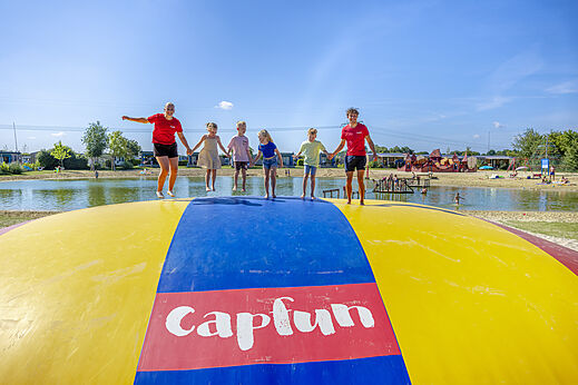 Groot springkussen met kinderen en animatoren op camping CAPFUN De Fruithof in Klijndijk.