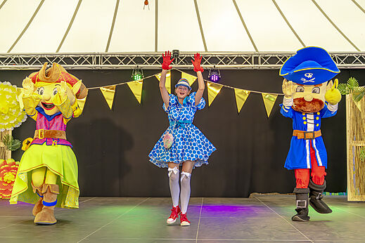 Maskottchenfiguren und Animateurin auf Bühne für Show auf dem Campingplatz CAPFUN De Fruithof in Klijndijk.